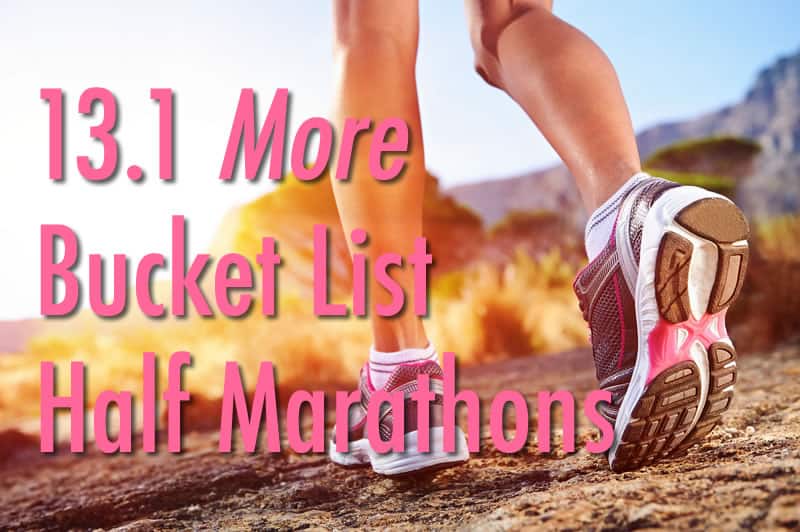 Close-up of a runner's legs in motion on a trail with the text "13.1 More Bucket List Half Marathons" superimposed in pink and white. The runner is wearing white and pink athletic shoes, with a scenic background of trees and hills under sunny skies.