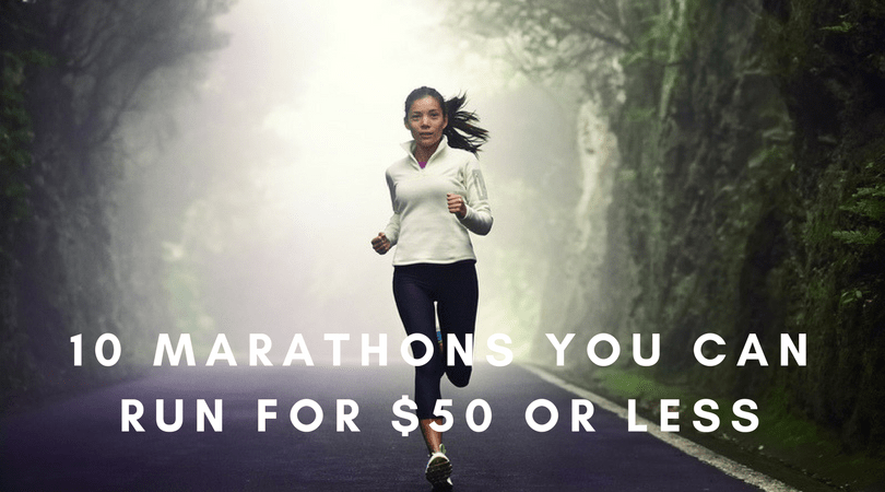 A person runs down a foggy, tree-lined road. They are wearing a white jacket and black leggings. The text over the image reads "10 Marathons You Can Run For $50 Or Less.