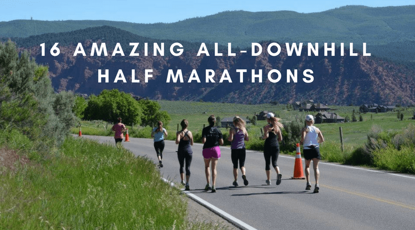 A group of runners is participating in a half marathon on a scenic rural road with mountains in the background. The image is overlaid with the text "16 Amazing All-Downhill Half Marathons.