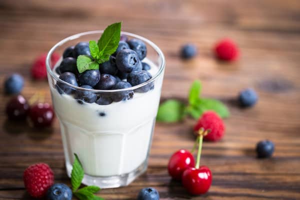 A glass of yogurt with berries.