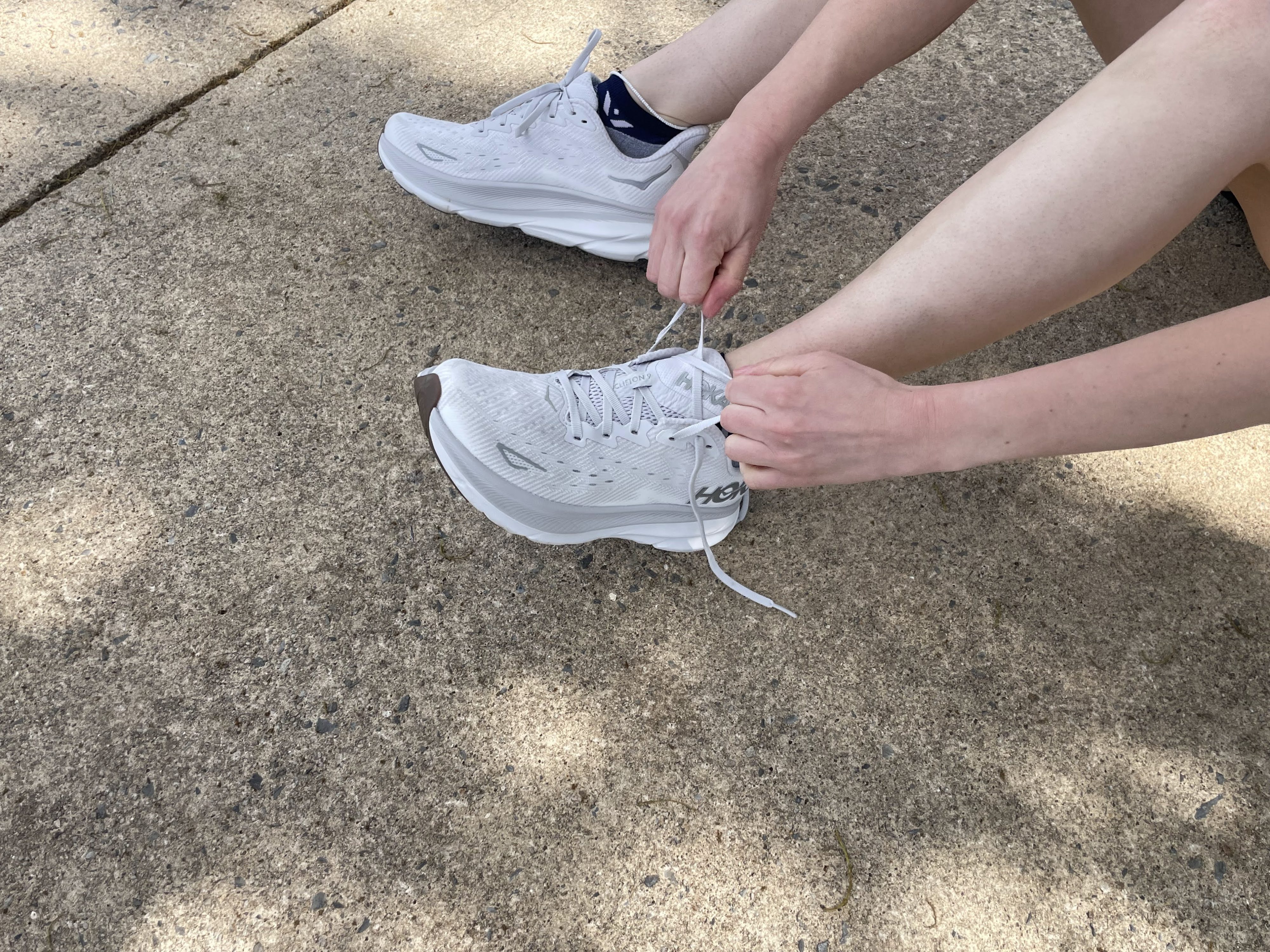 Writer Gabrielle Hondorp lacing up her Hoka Clifton 9 running shoes to test them for her review.