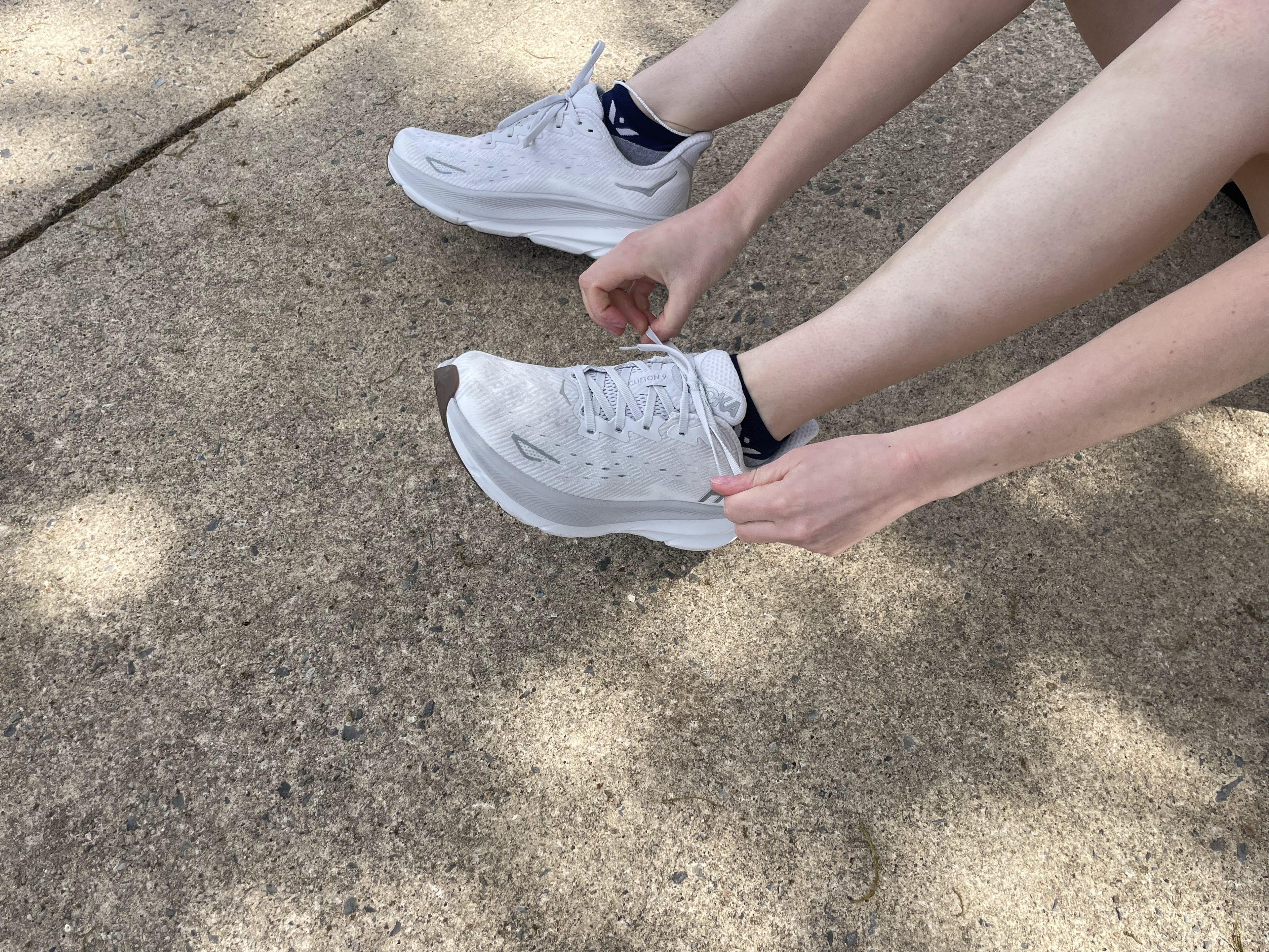 Writer Gabrielle Hondorp tying the Hoka Clifton 9 running shoes during testing, before a run.