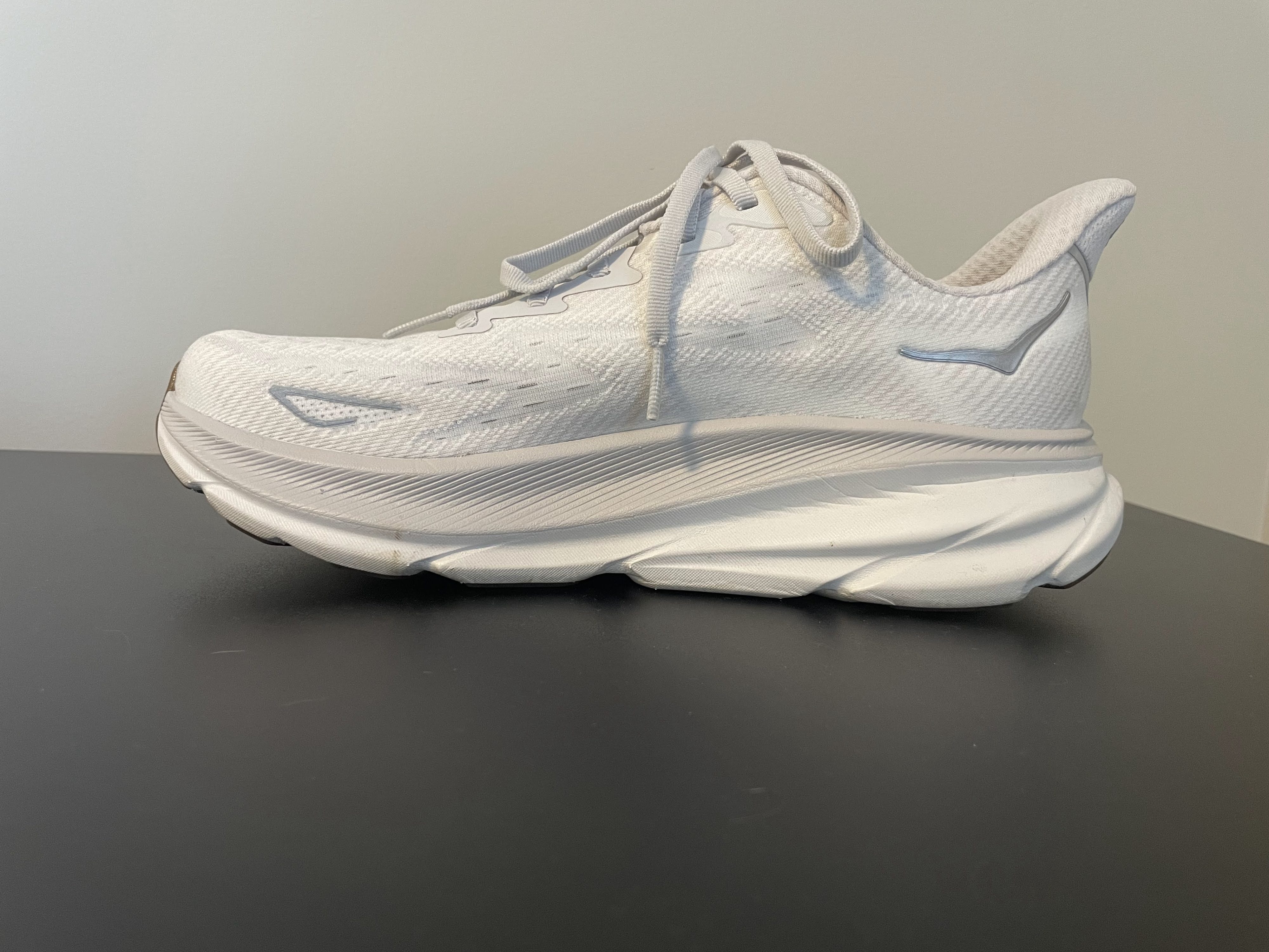 A side view of the Hoka Clifton 9 running shoes in white.