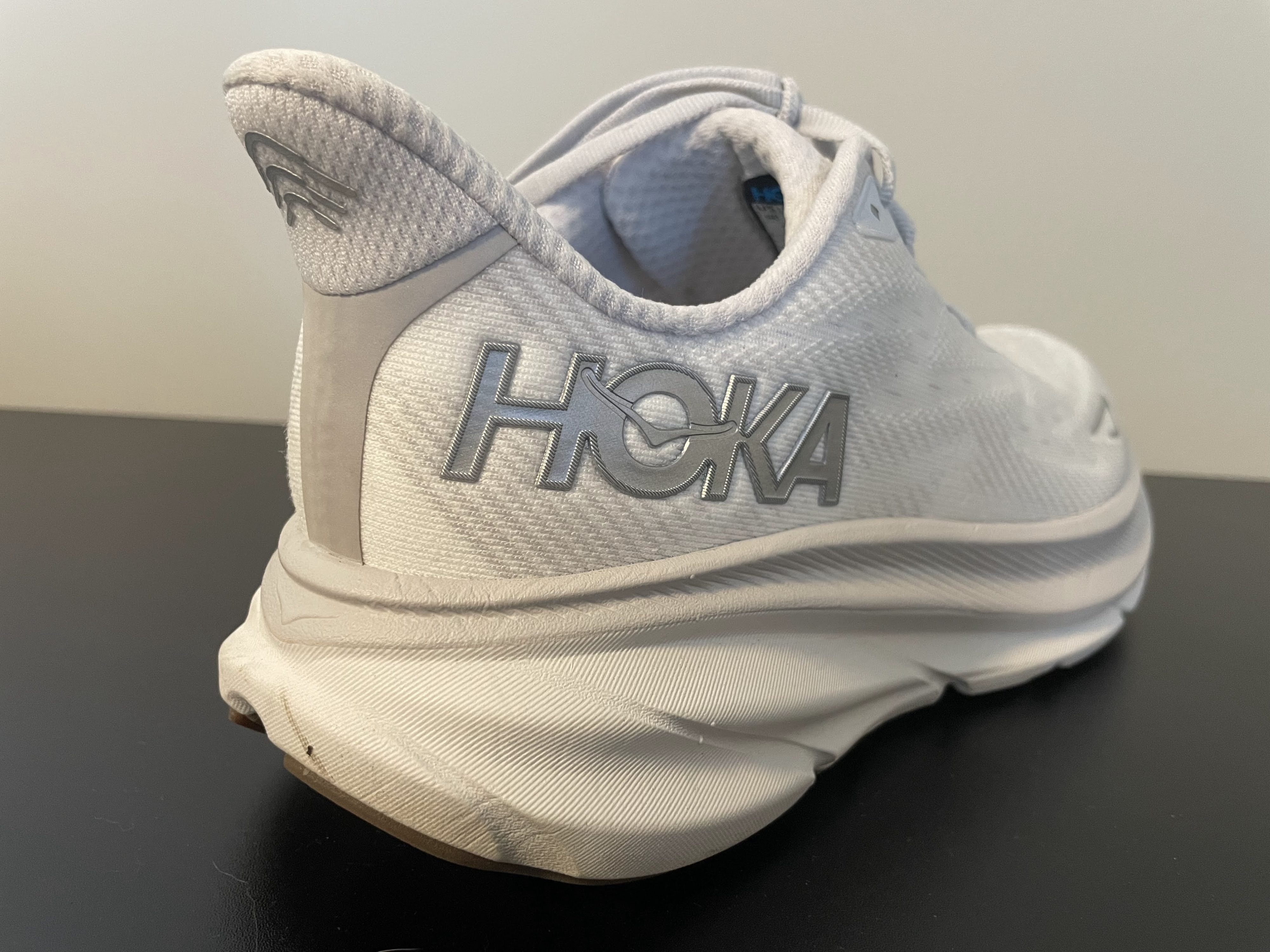 The heel of a Hoka Clifton 9 shoe displaying the brand name.