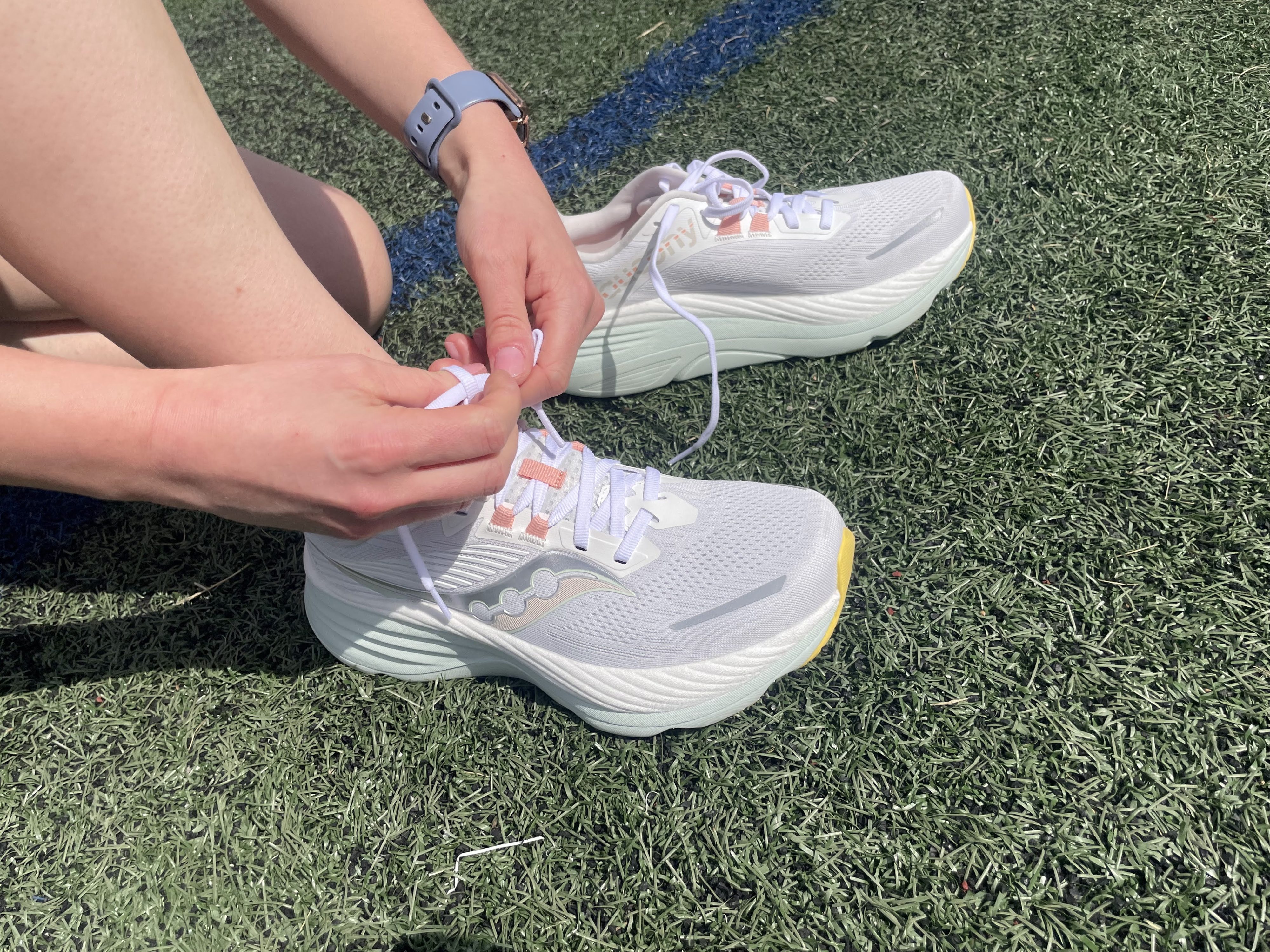 The Saucony Hurricane 24 sitting on astroturf, being laced up for a test run.